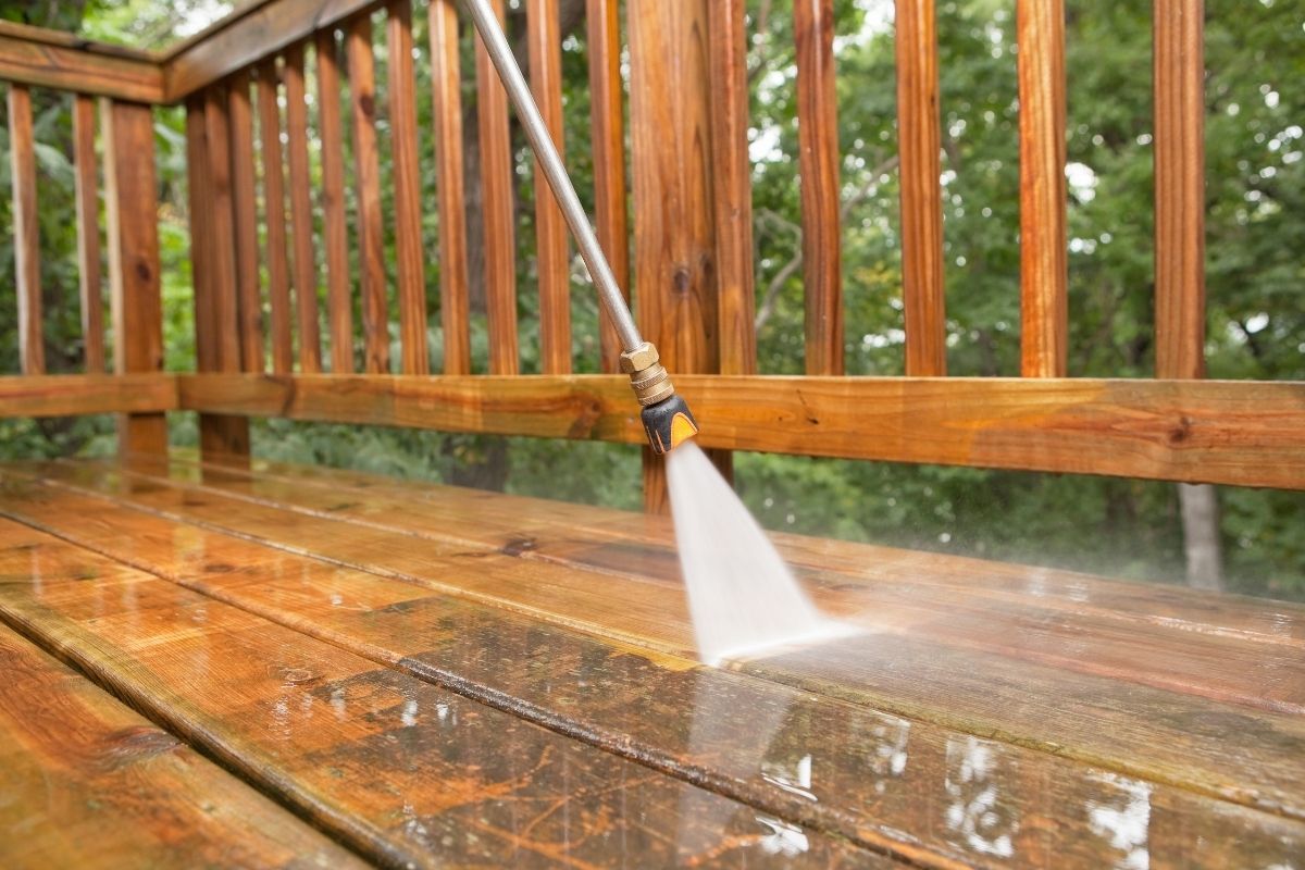 in the middle of pressure washing wooden patio and deck
